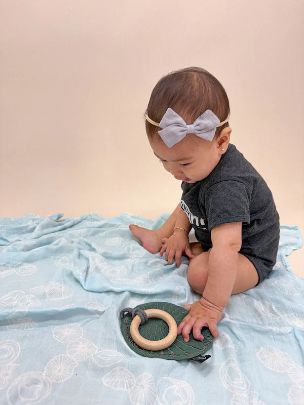 Pop-Up Mākeke - The Keiki Department - Bamboo Muslin Baby Swaddle Blanket - Blue Opihi Shells - In Use