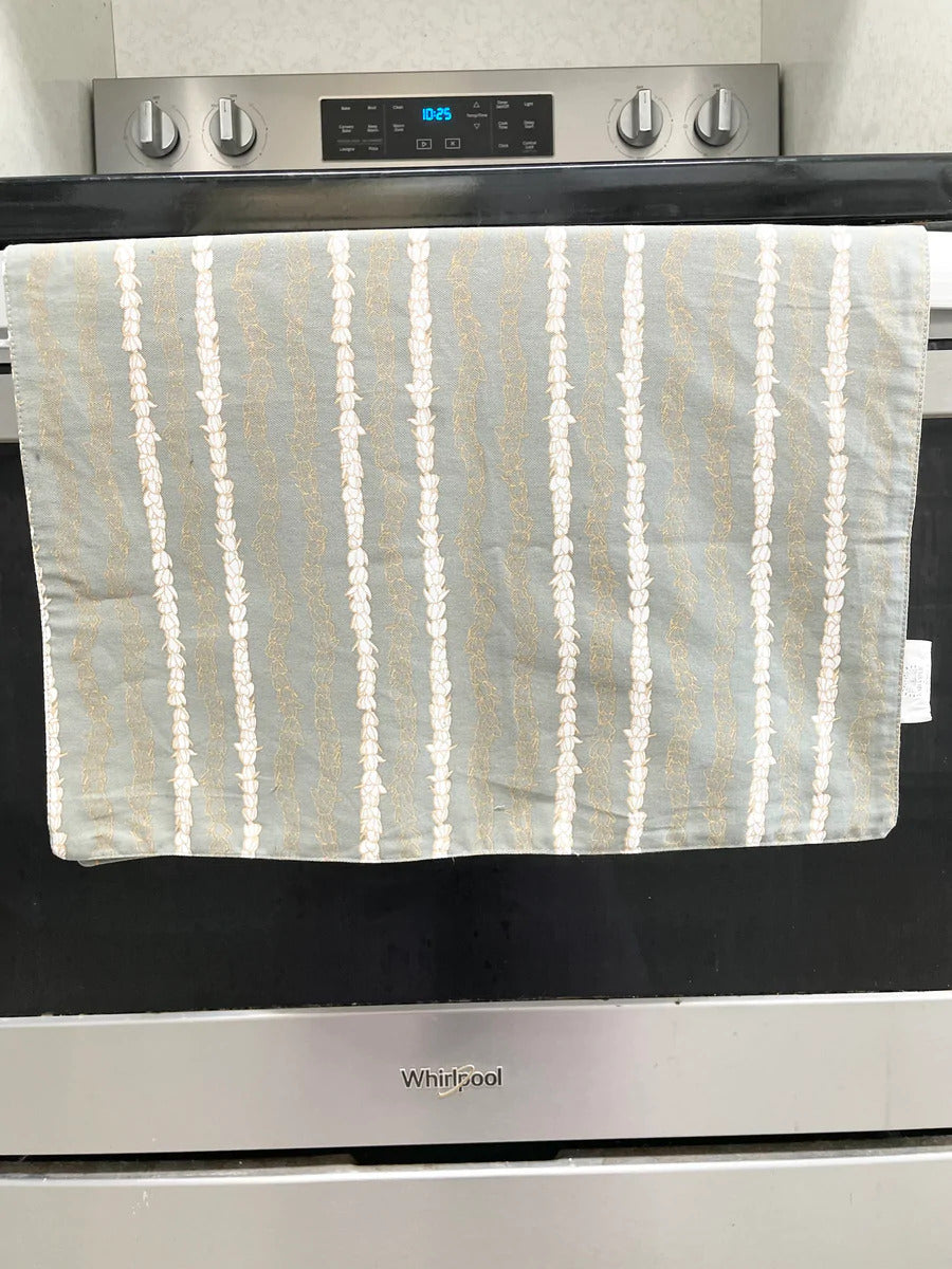Pop-Up Mākeke - Laha'ole Designs - Pikake Lei Hinahina (Grey) Tea Towel - In Use